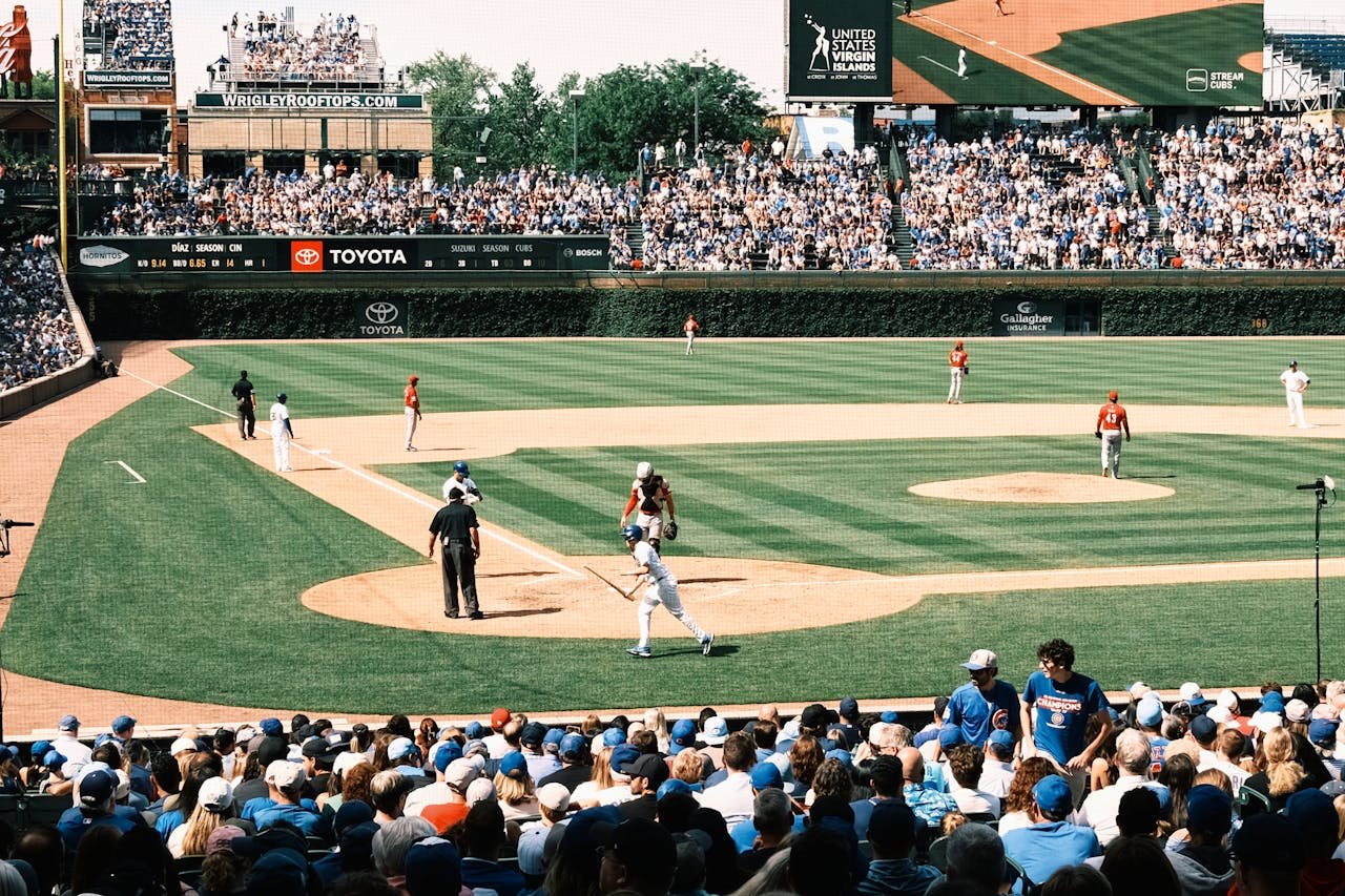 Vibrant scene of a baseball game at Wrigley Field with packed grandstands and players in action.